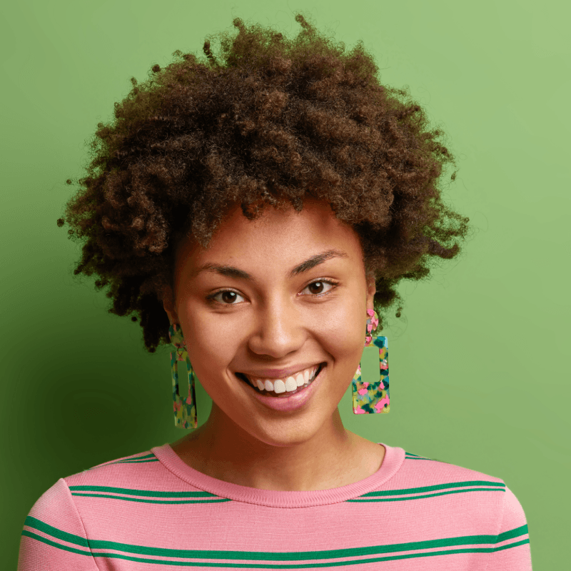 Close-up portrait of a smiling curly-haired girl